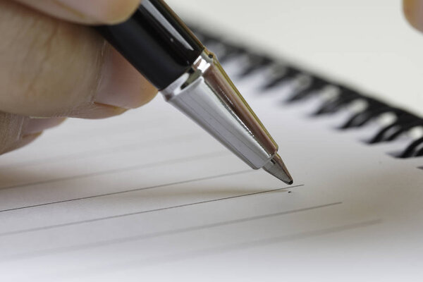 Hand holding a pen, close up