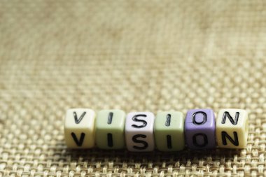 Ahşap bir yüzeyüzerinde alfabe boncuk vizyon ifadeler. seçici odaklama