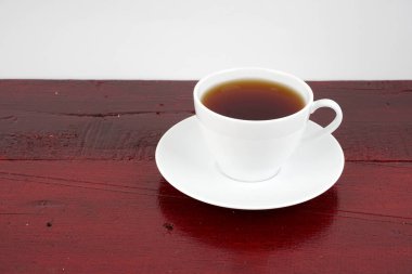 kahverengi masa yüzeyinde plaka ile siyah çay fincan, kopya alanı