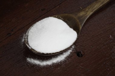 tahta kaşık üzerinde beyaz soda yığını