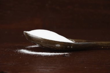 tahta kaşık üzerinde beyaz soda yığını