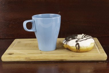 mavi çay bardağı ve Donut veya ahşap bir tahta üzerinde çörek 