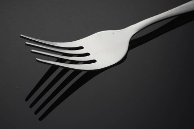 gümüş, yansıma ile siyah yüzeyüzerinde bir paslanmaz çatal 