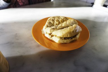 Fıstık ezmeli çörek ve portakal tabağı sehpada.