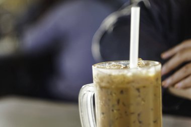 Bulanık arka planı olan bir bardak sütlü kahve.