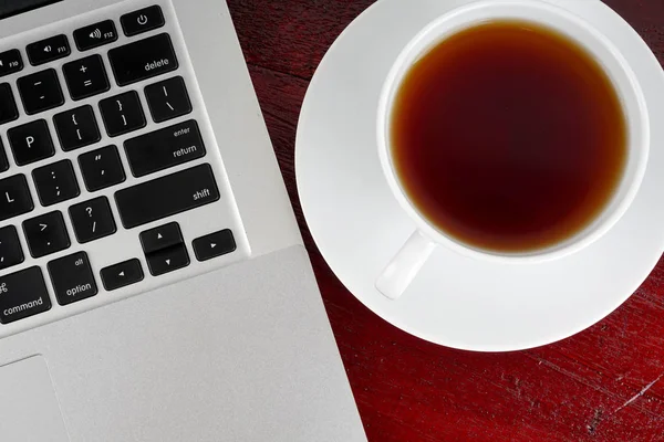 Tasse Schwarzen Tee Mit Teller Auf Der Tischfläche Mit Laptop — Stockfoto