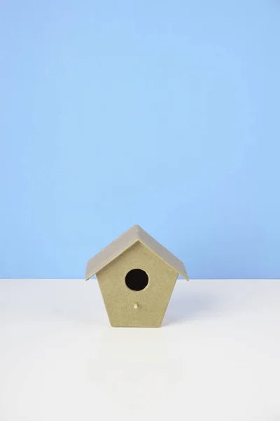 青い壁の背景にスタジオで木製の小鳥の家 — ストック写真