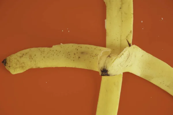 赤い背景にバナナの皮 — ストック写真