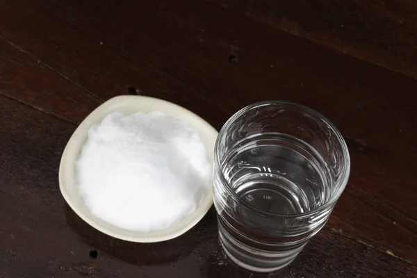 碗盘和一杯清水中一堆白苏打水 — 图库照片