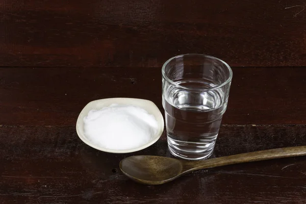 白碗盘 木勺和一杯水中的白苏打水堆 — 图库照片