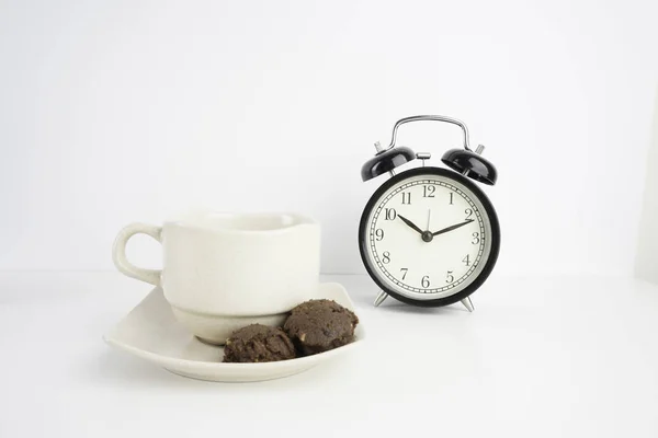 工作室拍摄的茶杯与饼干和报警模拟时钟 — 图库照片