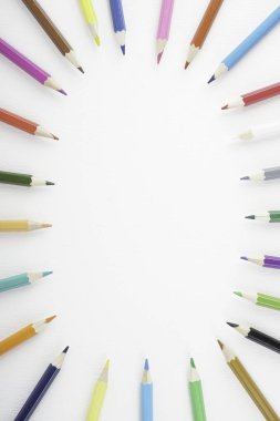 Beyaz kağıt üzerinde gökkuşağı renkli kalemler 