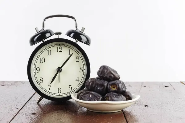 アラームアナログ時計とテーブル上の白いボウルプレートの果物を日付 — ストック写真
