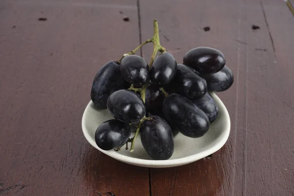 Purple Grapes White Bowl Plate Wooden Table Surface — Stock Photo, Image