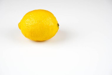 beyaz masa yüzeyinde bir bütün sarı limon 