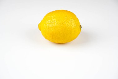 beyaz masa yüzeyinde bir bütün sarı limon 