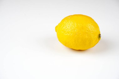 beyaz masa yüzeyinde bir bütün sarı limon 