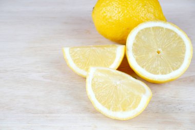 beyaz masa yüzeyinde ekşi sarı limon dilimleri