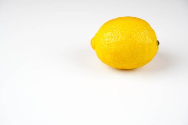 beyaz masa yüzeyinde bir bütün sarı limon 