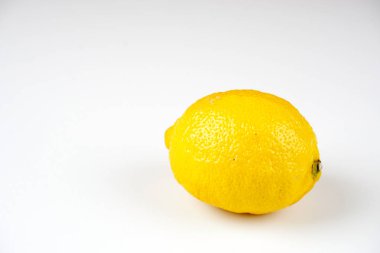 beyaz masa yüzeyinde bir bütün sarı limon 