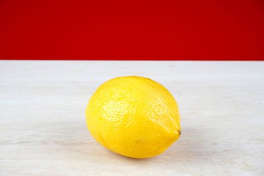 beyaz masa yüzeyinde bir bütün sarı limon 