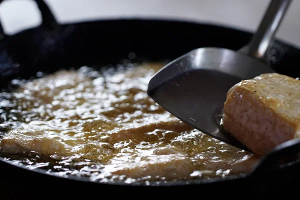 bean curd frying in pan in oil, closeup