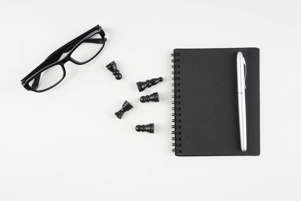 Schachfiguren Brille Lehrbuch Und Stift Auf Weißer Oberfläche — Stockfoto