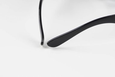 beyaz arka plan üzerinde siyah çerçeve gözlük kısmi görünümü