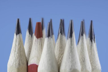 ahşap kalemler ve mavi arka plan karşı bir kırmızı keskin kalem