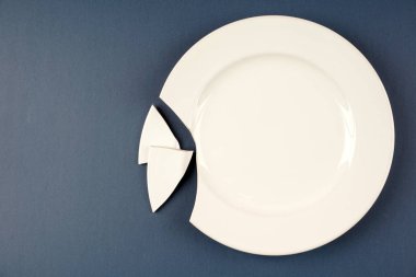 mavi yüzeyüzerinde bir beyaz porselen kırık plaka 