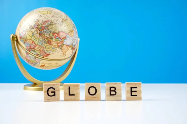 Globo Sobre Fondo Azul Texto Globe Sobre Una Superficie Madera —  Fotos de Stock