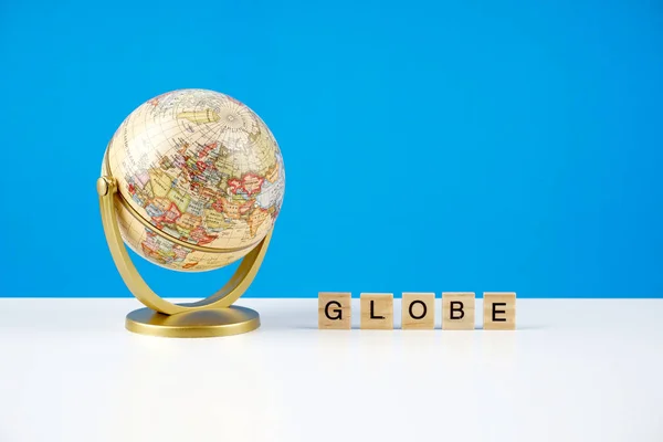 Globo Sobre Fondo Azul Texto Globe Sobre Una Superficie Madera — Foto de Stock