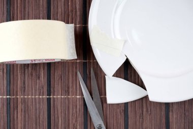 bant rulo, beyaz porselen kırık plaka ve makas
