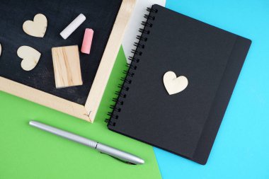 siyah tahta ve renkli tebeşir ve sünger, günlük kitap ve kalem üzerinde boş alan 