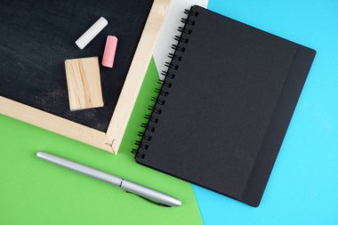 siyah tahta ve renkli tebeşir ve sünger, günlük kitap ve kalem üzerinde boş alan 