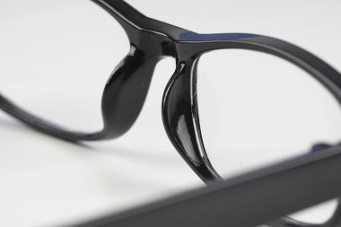 beyaz arka plan üzerinde siyah çerçeve gözlük kısmi görünümü