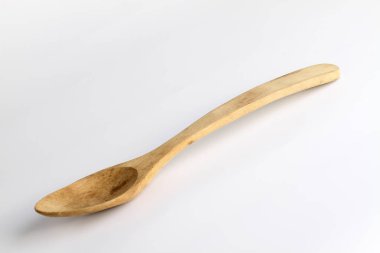 Beyaz arka planda elle oyulmuş ahşap kaşık..