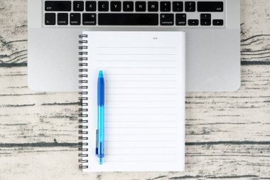 açık ders kitabı günlüğü sayfası ve kalem ve dizüstü bilgisayar klavyesi ile işyeri tablosu 