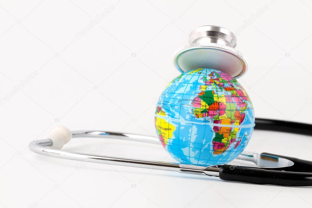 studio shot of small earth planet globe toy and stethoscope