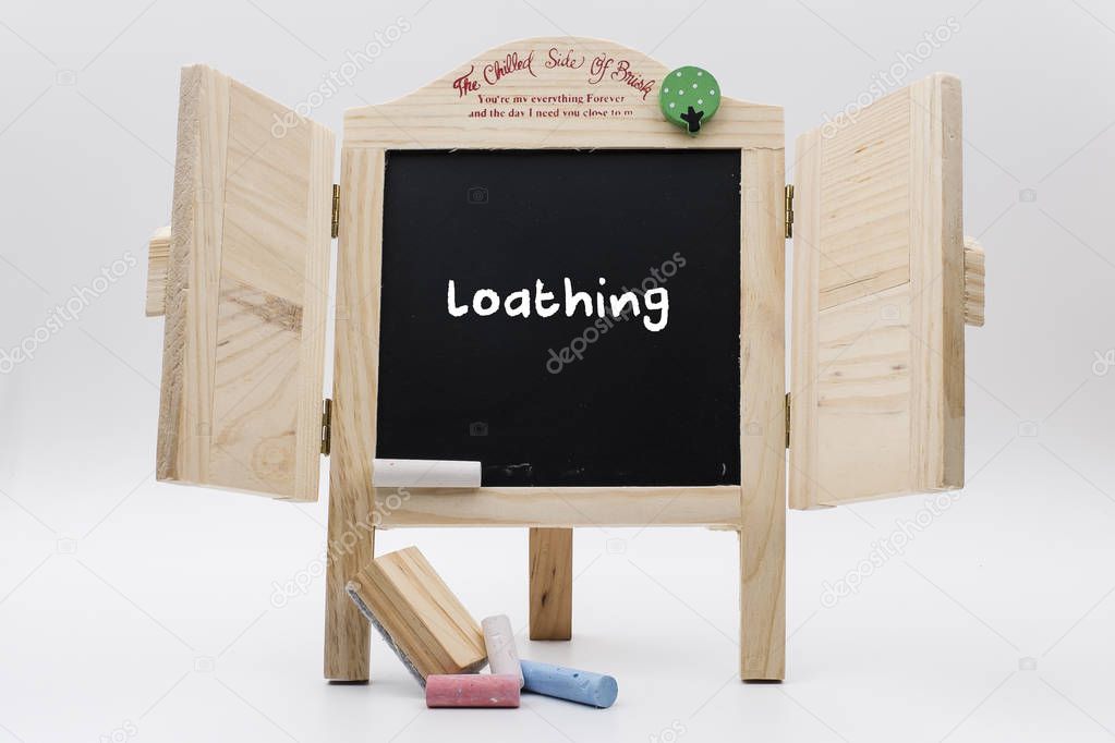 wooden blackboard with chalks and written text loathing 