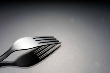 gümüş, stüdyoda gri yüzeyüzerinde bir paslanmaz çatal 