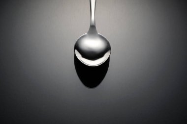 Gri yüzeyde gümüş kaşık