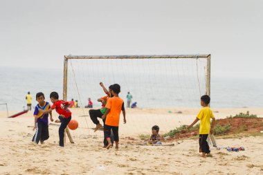 group of little boys playing beach football at island beach.