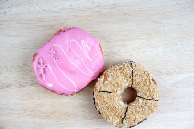 Tahta yüzeyde çeşitli donutların düz yatışı.