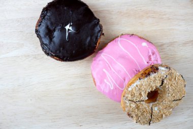 Tahta yüzeyde çeşitli donutların düz yatışı.