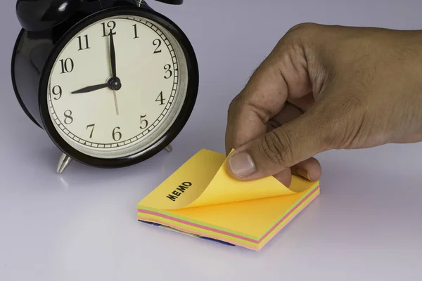 a hand taking the sticky note from the stack