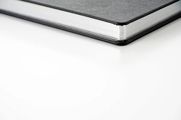 工作室白色表面的黑色封面纸教科书日记 — 图库照片