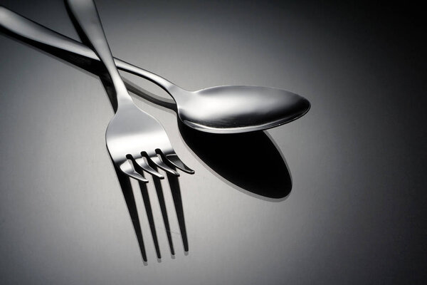 silverware, stainless fork and spoon on grey surface 