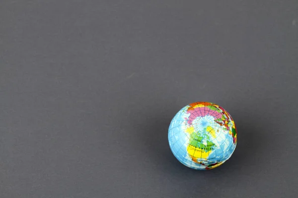 studio shot of small earth planet globe toy isolated on grey