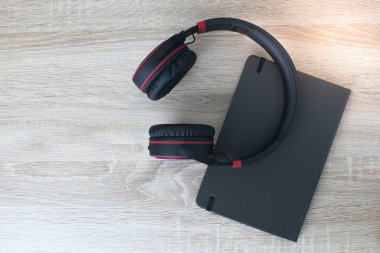 Kulaklık ve not defteri ahşap arka planda 